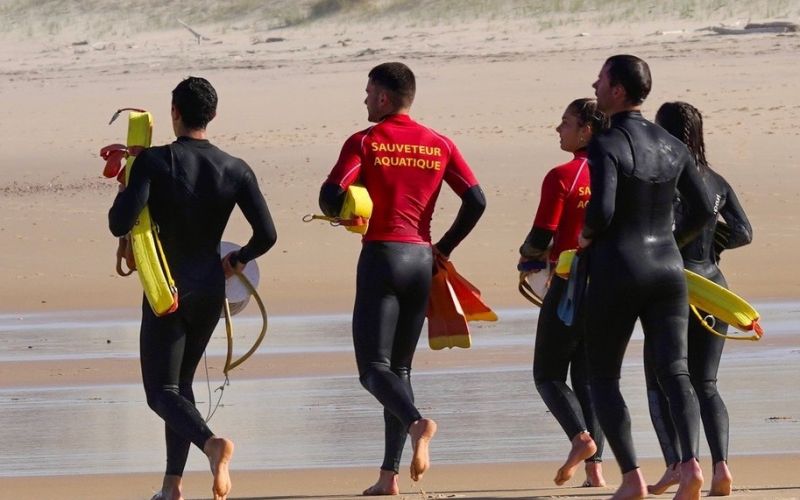 sauveteurs sur la plage portant materiel